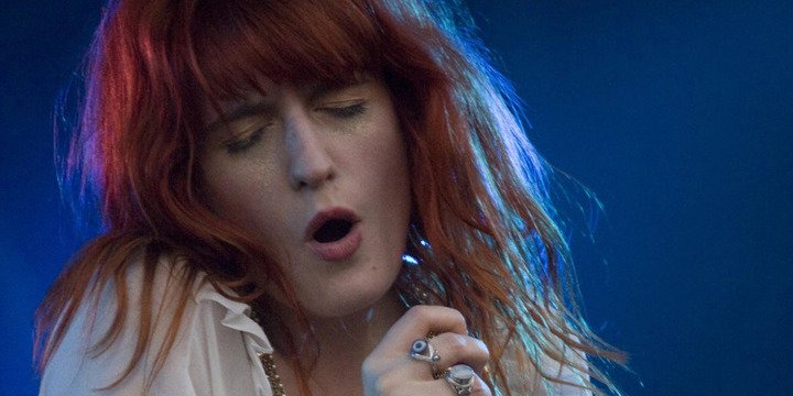 red haired woman singing into mic