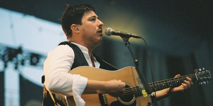 man singing into guitar