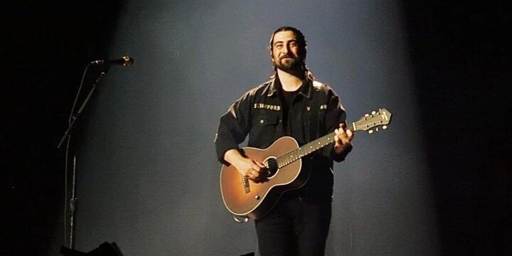man holding guitar on stage