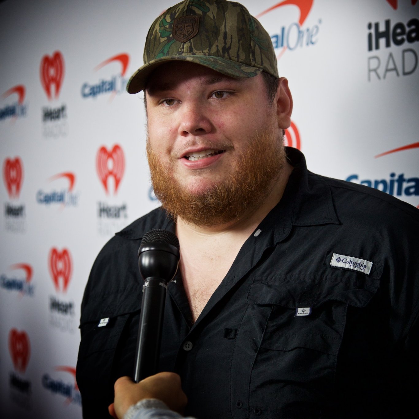 luke_combs_interview-by-david-bergman-is-licensed-under-cc-by-sa-4-0 Man with cap and ginger beard being interviewd